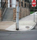 A photograph shows a misplaced pole in the middle of a curb-cut.